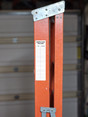 White ladder inspection record label with space for dates and initials on orange ladder